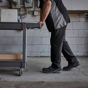 man wearing mens black CSA work shoes with blue accents while pushing cart at work