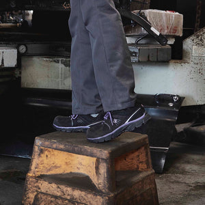 woman wearing black and purple CSA work shoes while fixing a car