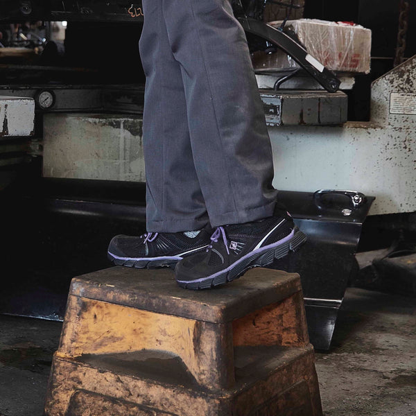 woman wearing black and purple CSA work shoes while fixing a car