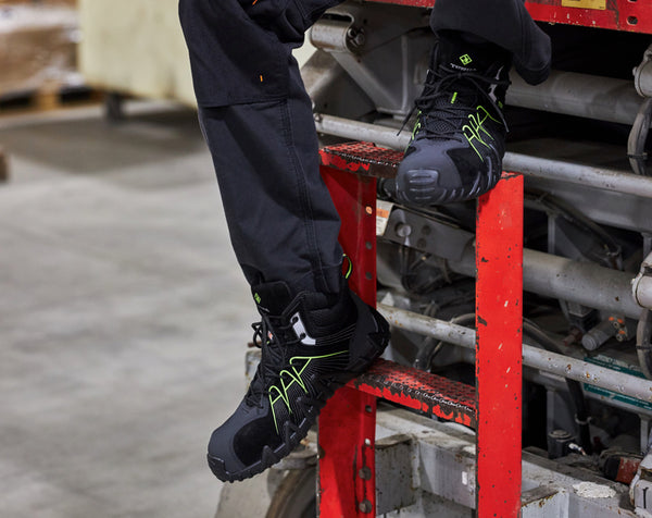 man climbing out of skyjack wearing suede CSA work boots with lime accents