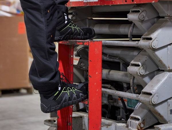 man climbing steps of skyjack wearing suede CSA work boots with lime accents 